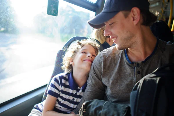 O jovem passa pelo ônibus junto com o filho . — Fotografia de Stock