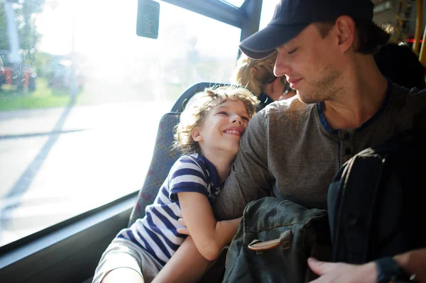 O jovem passa pelo ônibus junto com o filho . — Fotografia de Stock