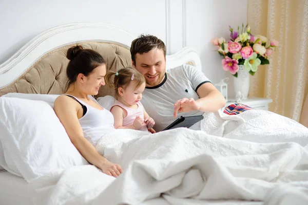 Young parents entertain the little daughter. — Stock Photo, Image