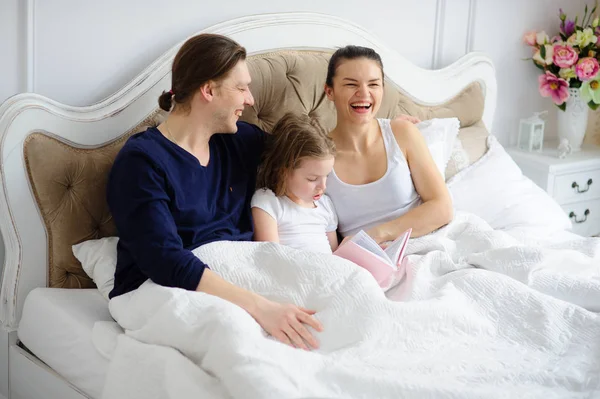 Het boek leest het dochtertje aan ouders. — Stockfoto