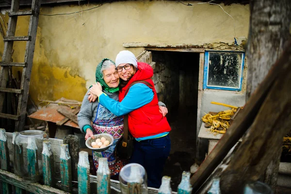 Молодая женщина обнимает старуху . — стоковое фото