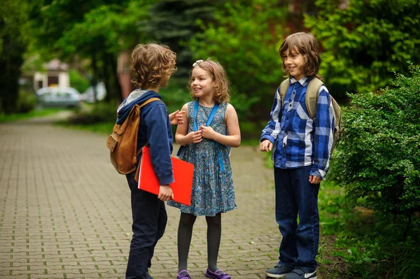 Lilla skolan studenter prata raskt och glatt på skolgården. — Stockfoto