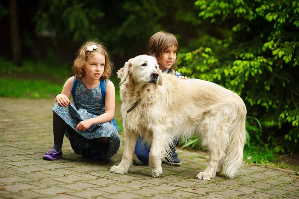 Los niños pequeños se reunieron en el camino a la escuela un perro grande . — Foto de Stock
