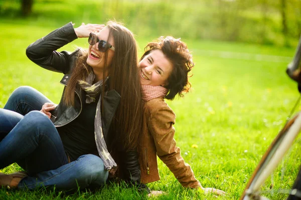 Twee mooie jonge vrouwen doorbrengen vrolijk tijd in het park voorjaarsbijeenkomst. — Stockfoto