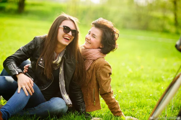 Twee mooie jonge vrouwen doorbrengen vrolijk tijd in het park voorjaarsbijeenkomst. — Stockfoto