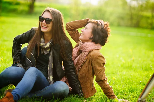 Twee mooie jonge vrouwen doorbrengen vrolijk tijd in het park voorjaarsbijeenkomst. — Stockfoto