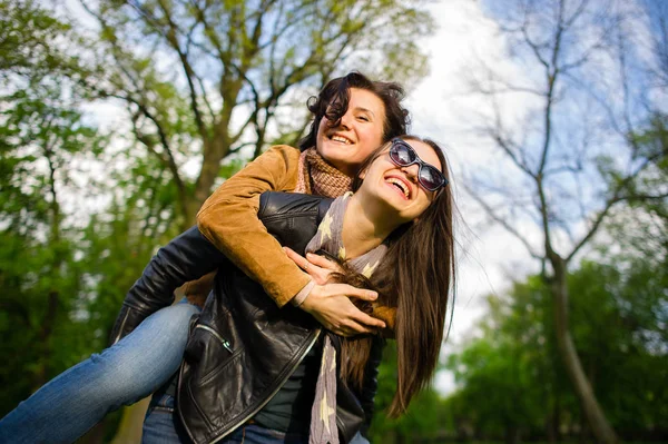 Twee schattige jonge vrouwen doorbrengen vrolijk tijd in het park voorjaarsbijeenkomst — Stockfoto