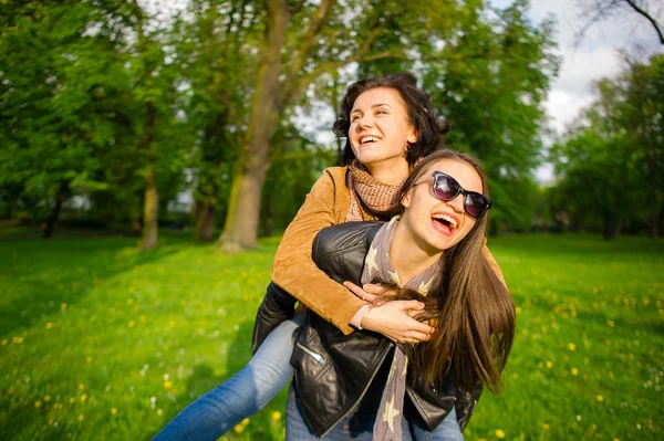 Twee schattige jonge vrouwen doorbrengen vrolijk tijd in het park voorjaarsbijeenkomst — Stockfoto