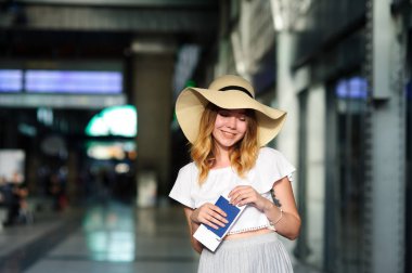 Pasaport ve bilet bir el ile geniş ekledi şapkalı güzel kız.