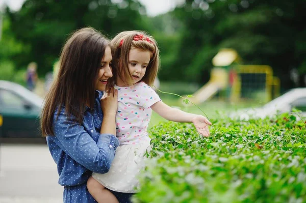 Young mother walks in the park with the little daughter. — Stock Photo, Image