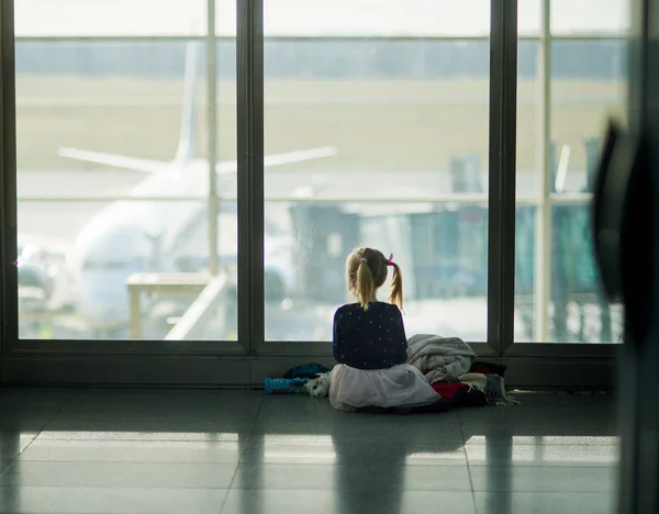 Маленькая девочка сидит возле большого окна в аэропорту . — стоковое фото