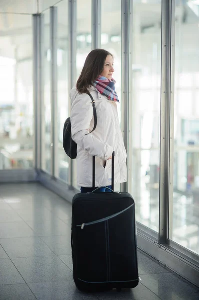 Η νεαρή γυναίκα με μια βαλίτσα στο αεροδρόμιο. — Φωτογραφία Αρχείου