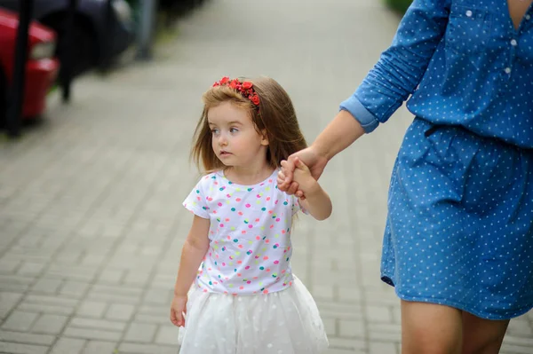 Genç anne parkta küçük kızı ile yürür..