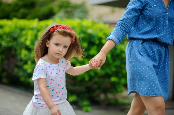 Genç anne parkta küçük kızı ile yürür..