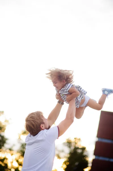 Jovem pai está brincando com uma filhinha encantadora . — Fotografia de Stock