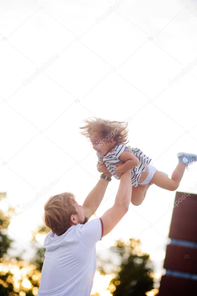 Young dad is playing with a charming little daughter.