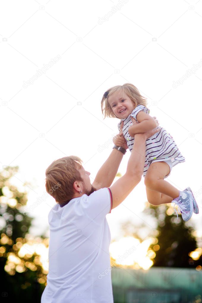 Young dad is playing with a charming little daughter.