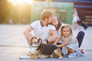 Harika genç aile yere oturmuş dinleniyor.