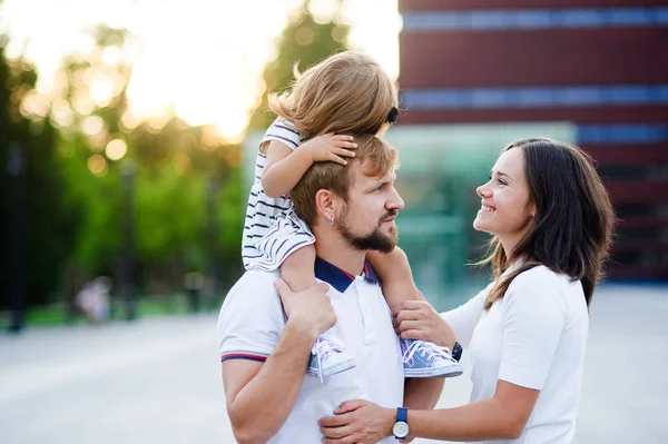 Família jovem bonito em um dia de verão na praça da cidade . — Fotografia de Stock