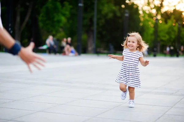 Schattig meisje loopt naar de bovenliggende handen. — Stockfoto