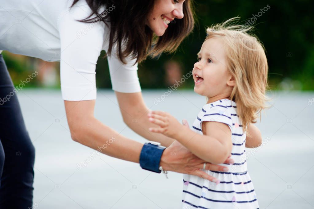 Young woman takes the little daughter on hands