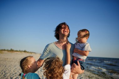 Baba kumsalda üç çocuklarla oynuyor.
