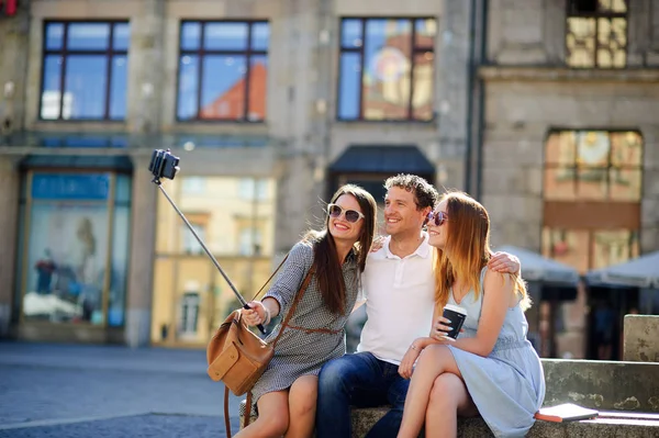 Group of young tourists makes selfie on the background of an old building — Stock Photo, Image