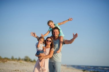 Genç ve mutlu bir aile sahilde.