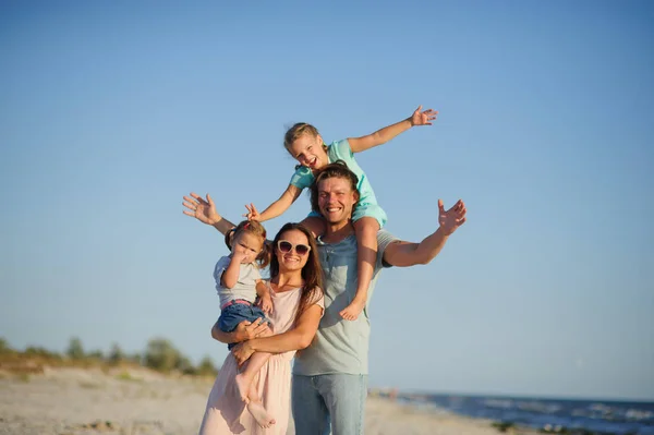 Genç ve mutlu bir aile sahilde.