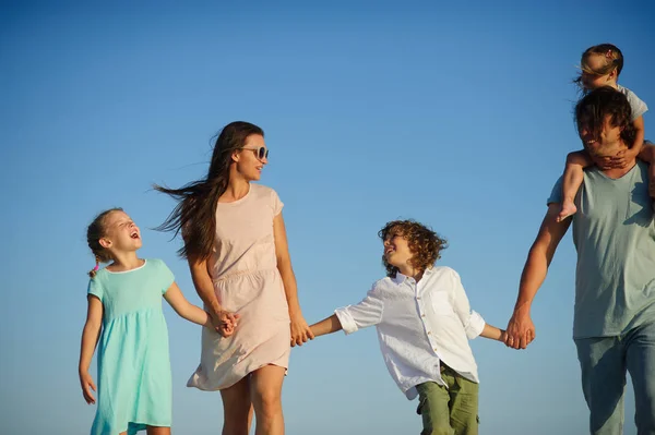 Grote en gelukkige familie wandelen op het strand. — Stockfoto