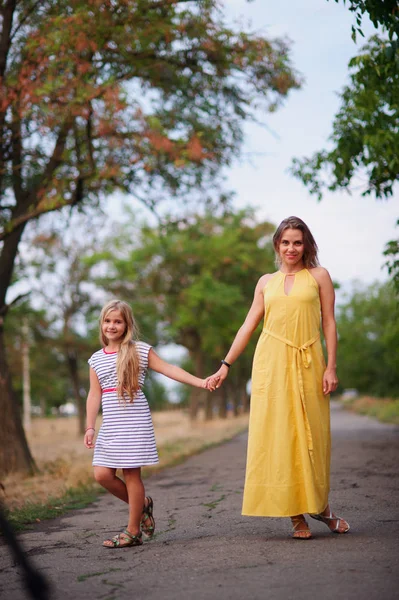 Moeder wandelingen met haar dochter in het park. — Stockfoto