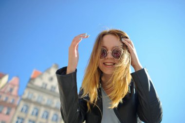 Sevimli genç kız güzel bir eski bina zemin karşı güneş gözlüğü.