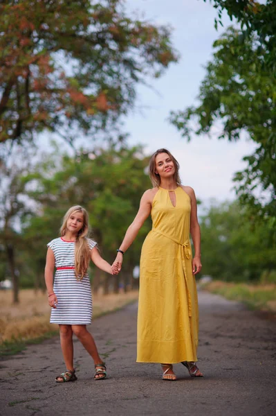 Moeder wandelingen met haar dochter in het park. — Stockfoto