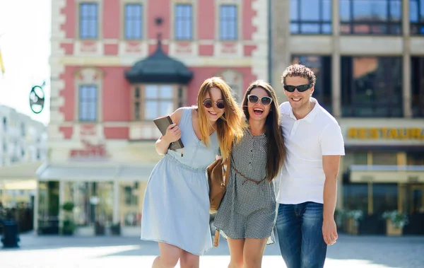 Üç genç insanlar antik kent meydanında stand.