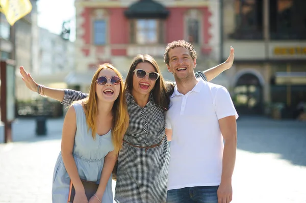 Üç genç insanlar antik kent meydanında stand.