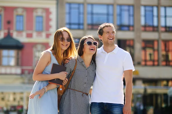 Üç genç insanlar antik kent meydanında stand.