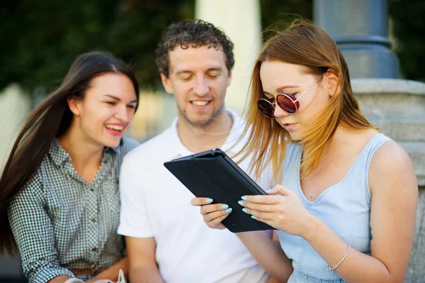 İki hatun ve ilgi ile adam tablet ekrana bak.