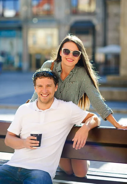 Joyeux jeune couple sur un banc . — Photo