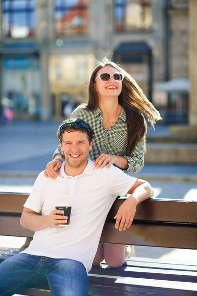Joyeux jeune couple sur un banc . — Photo