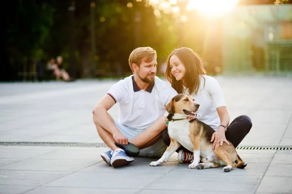 Cute young couple sits on the earth closely having nestled to each other. — Stock Photo, Image