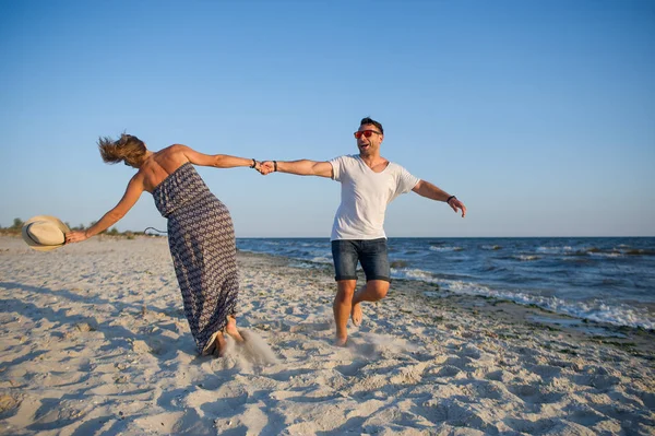 Man en vrouw cirkelen in de dans op het strand. — Stockfoto
