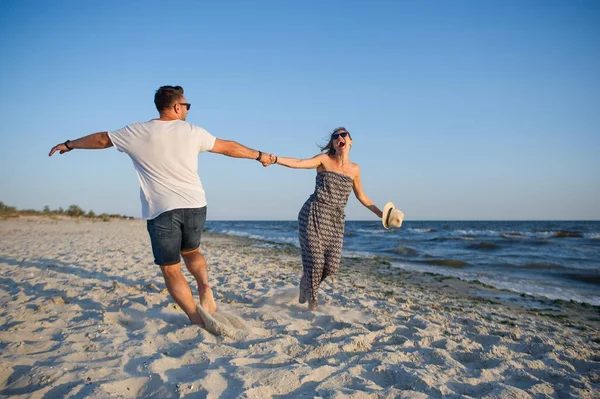 Erkek ve kadın sahilde dans çember. — Stok fotoğraf