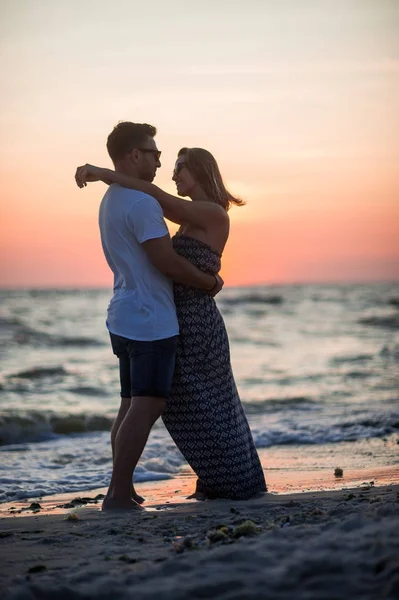 Paar liefhebbers staat aan de kust hebben omarmd. — Stockfoto