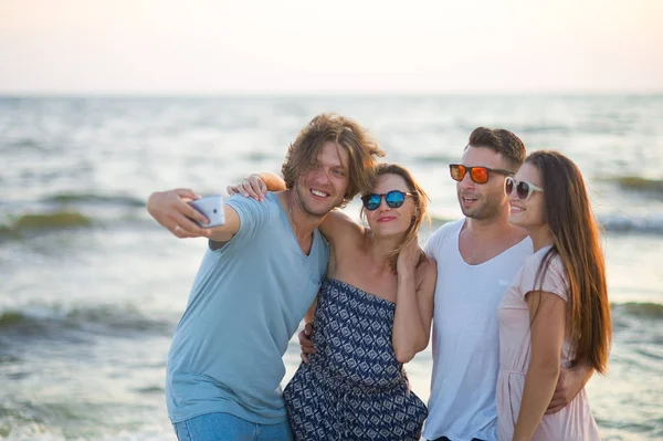 Grupo de jóvenes alegres fotografiados en la playa . — Foto de Stock