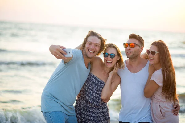 Grupo de jóvenes alegres fotografiados en la playa . — Foto de Stock