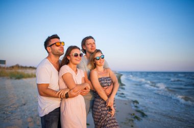 İki Genç çiftler bir günbatımı'nın deniz kıyısında hayranım..