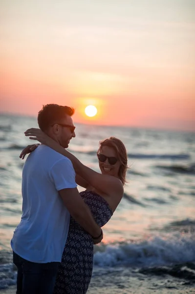 Deniz kıyısı üzerinde kucakladı çift aşıkların standları. — Stok fotoğraf