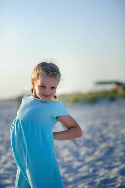 9-10 yıllık bir mavi elbiseli bir kız portresi.