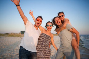 İki Genç çiftler bir günbatımı'nın deniz kıyısında hayranım..