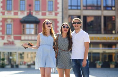 Üç genç insanlar antik kent meydanında stand.